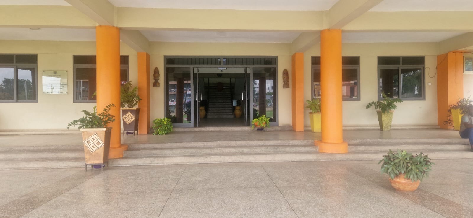 Entrance of a partner institution with orange pillars and potted plants