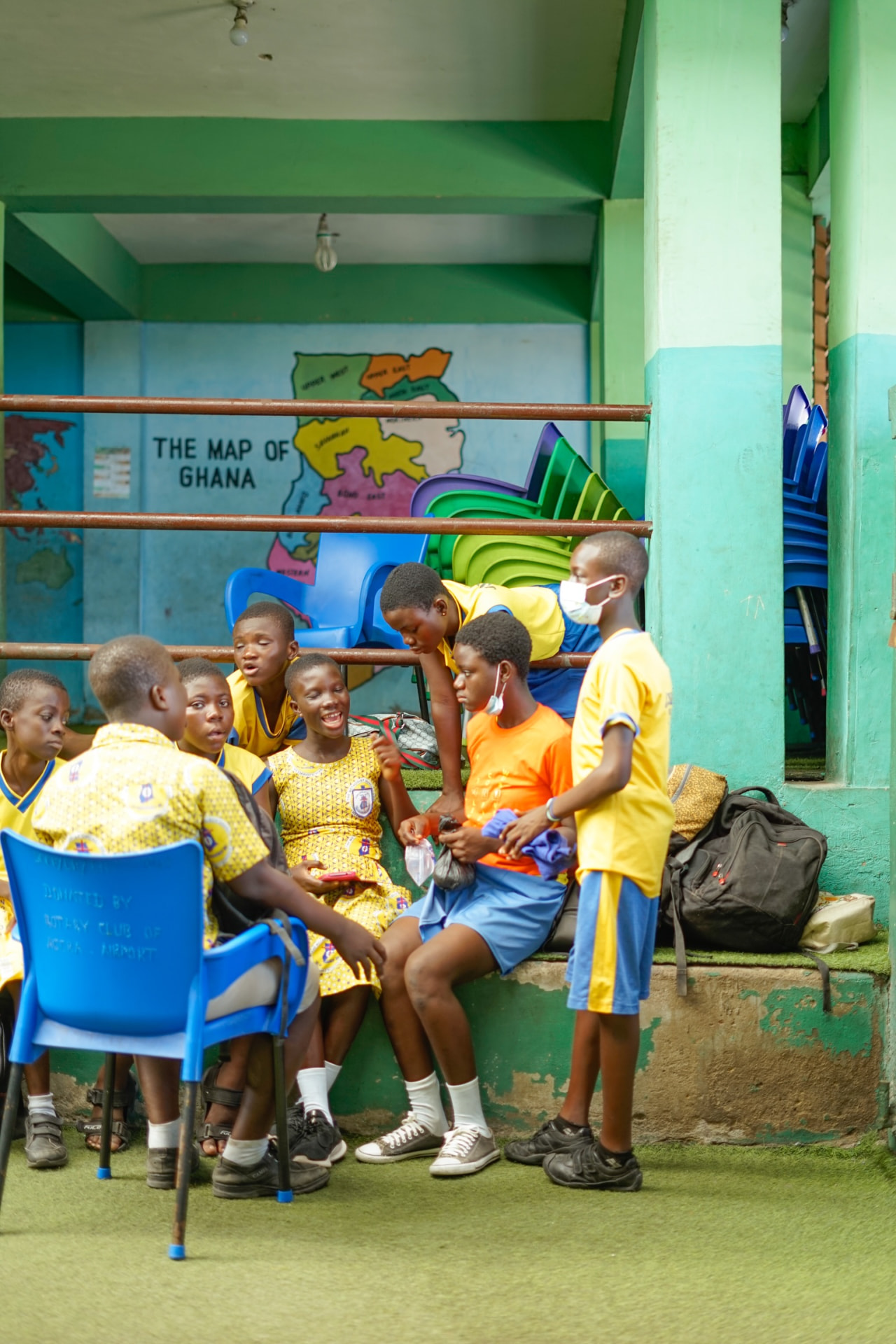 Students in school uniform sitting together and talking during a RANT session in Ghana