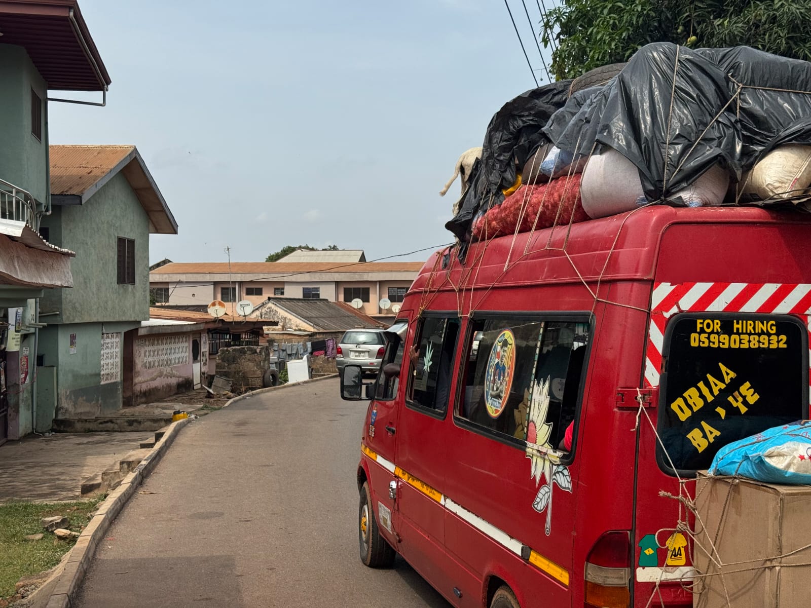 Loaded trotro van on a residential road in Ghana