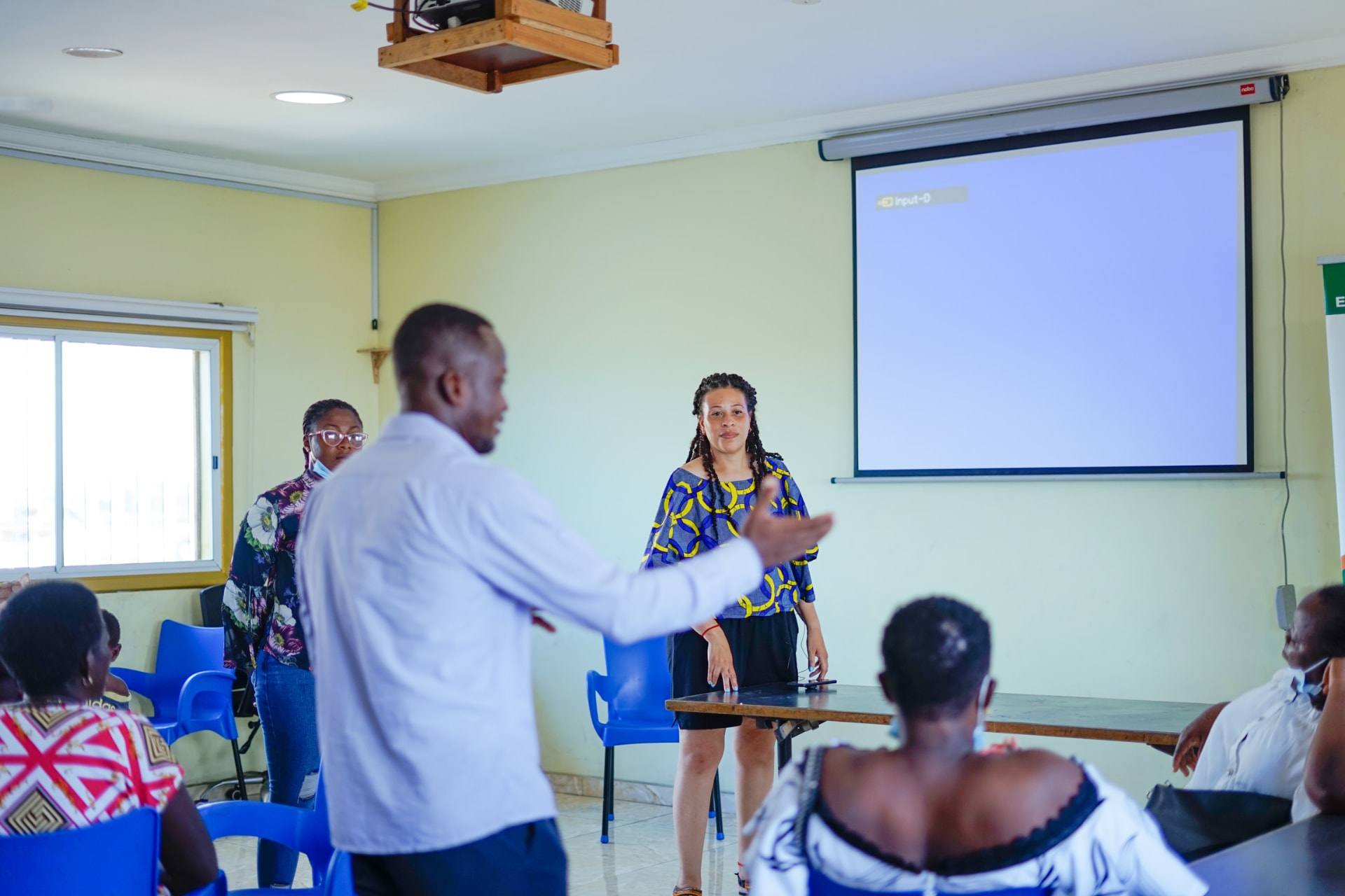 Facilitator leading a teacher training workshop with participants seated in a classroom