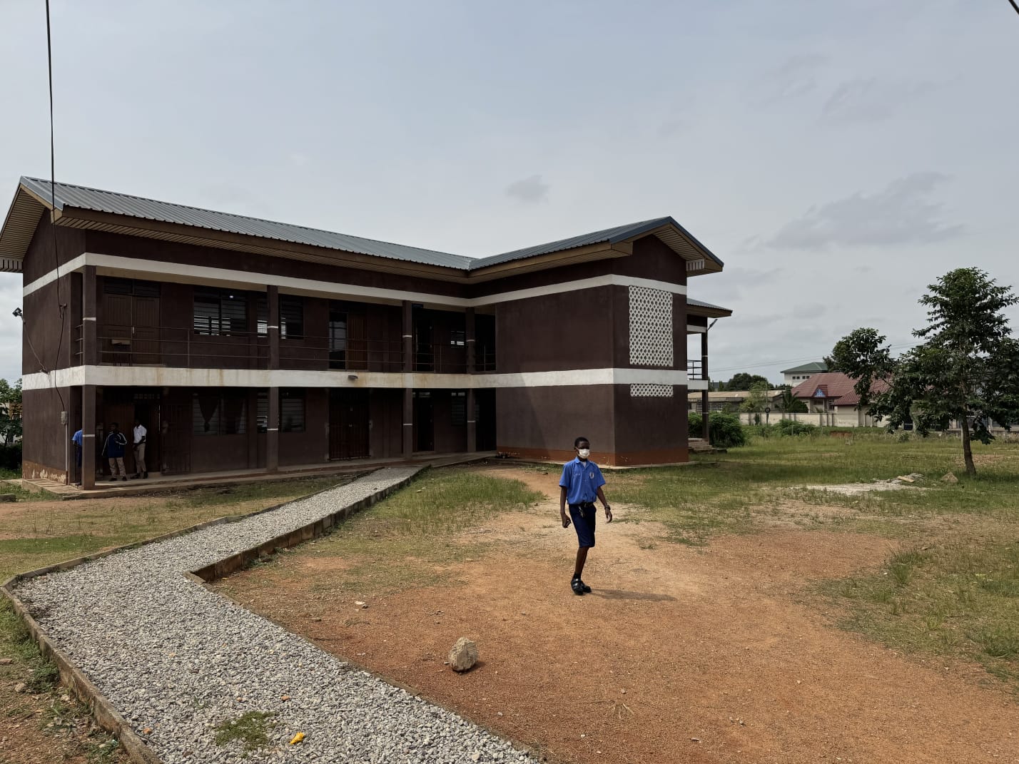 Student walking across the grounds of a technical institute teaching block