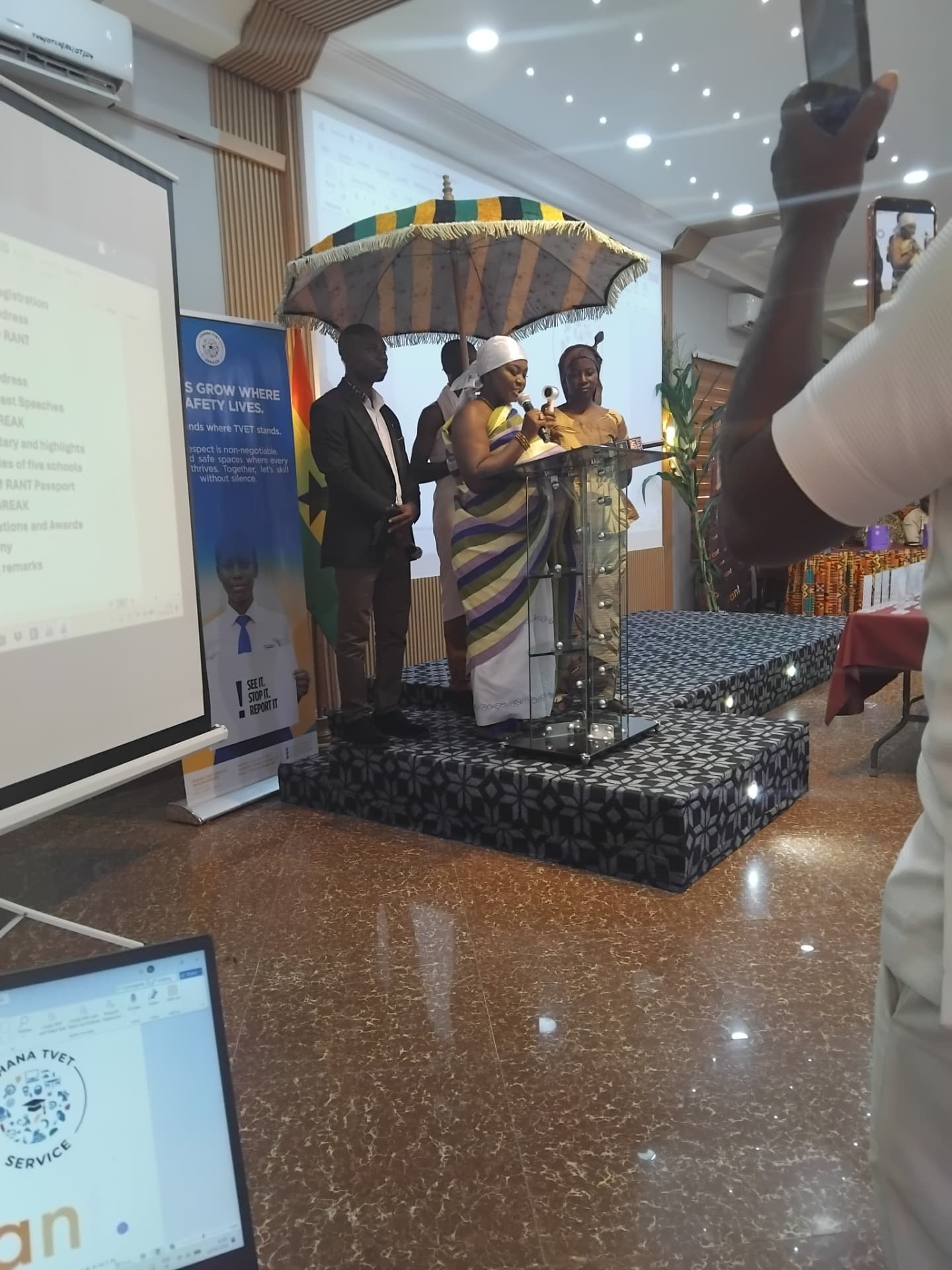 Traditional leaders in kente cloth speaking under a ceremonial umbrella at the RANT launch event