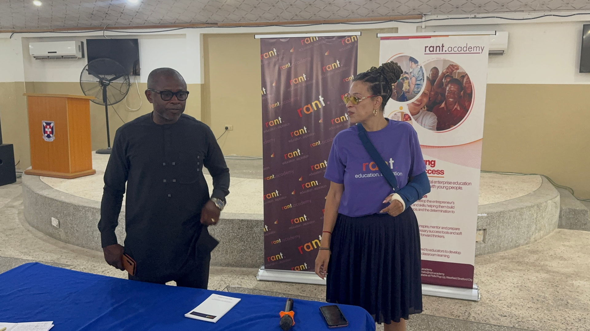 RANT Director Elizabeth Lambie with the Regional Director of the Ashanti Region in front of RANT Academy banners