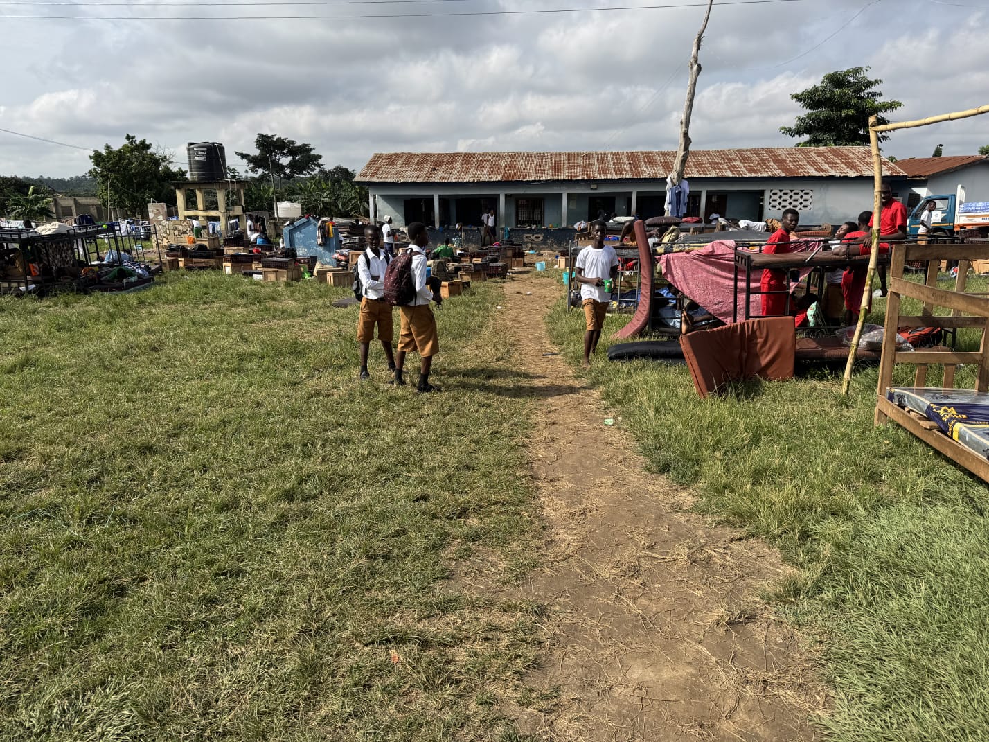 Students walking across school grounds past dormitory furniture set out to air